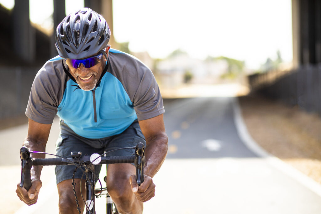 Senior Black Man Racing on a Road Bike